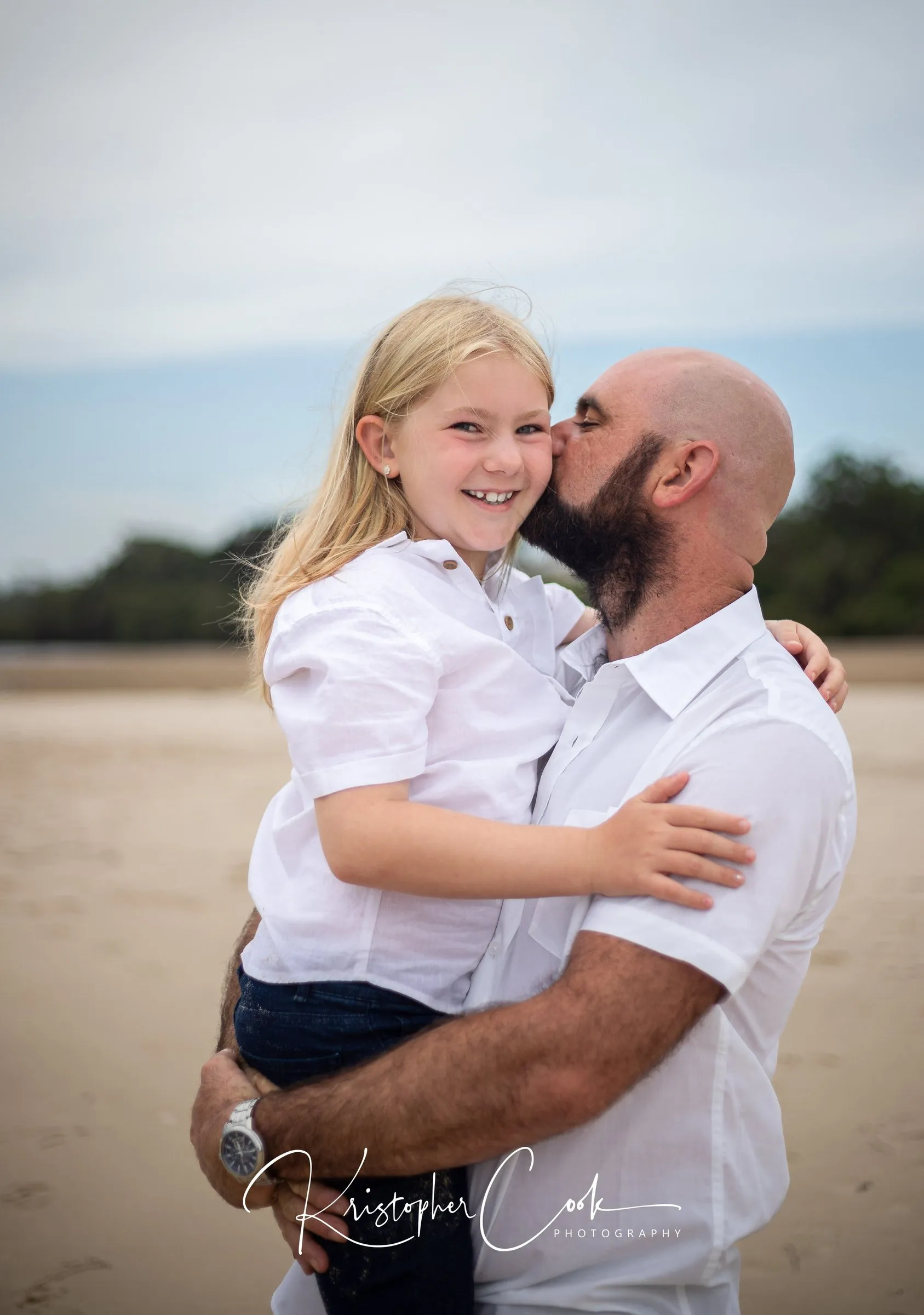 Father holding his daughter on the beach at Ballina, photographed by Kris Cook