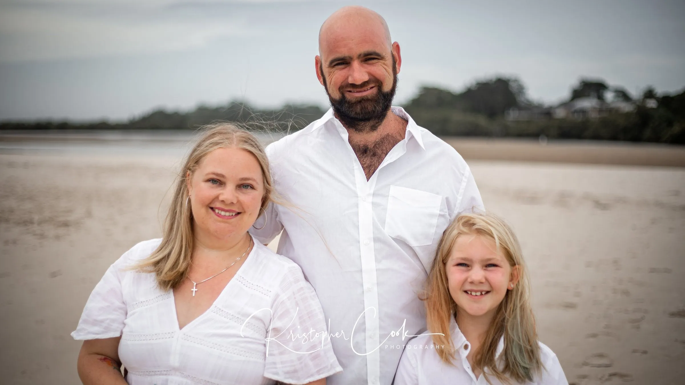 Family of three on the sand at low tide near Ballina, photographed by Kris Cook