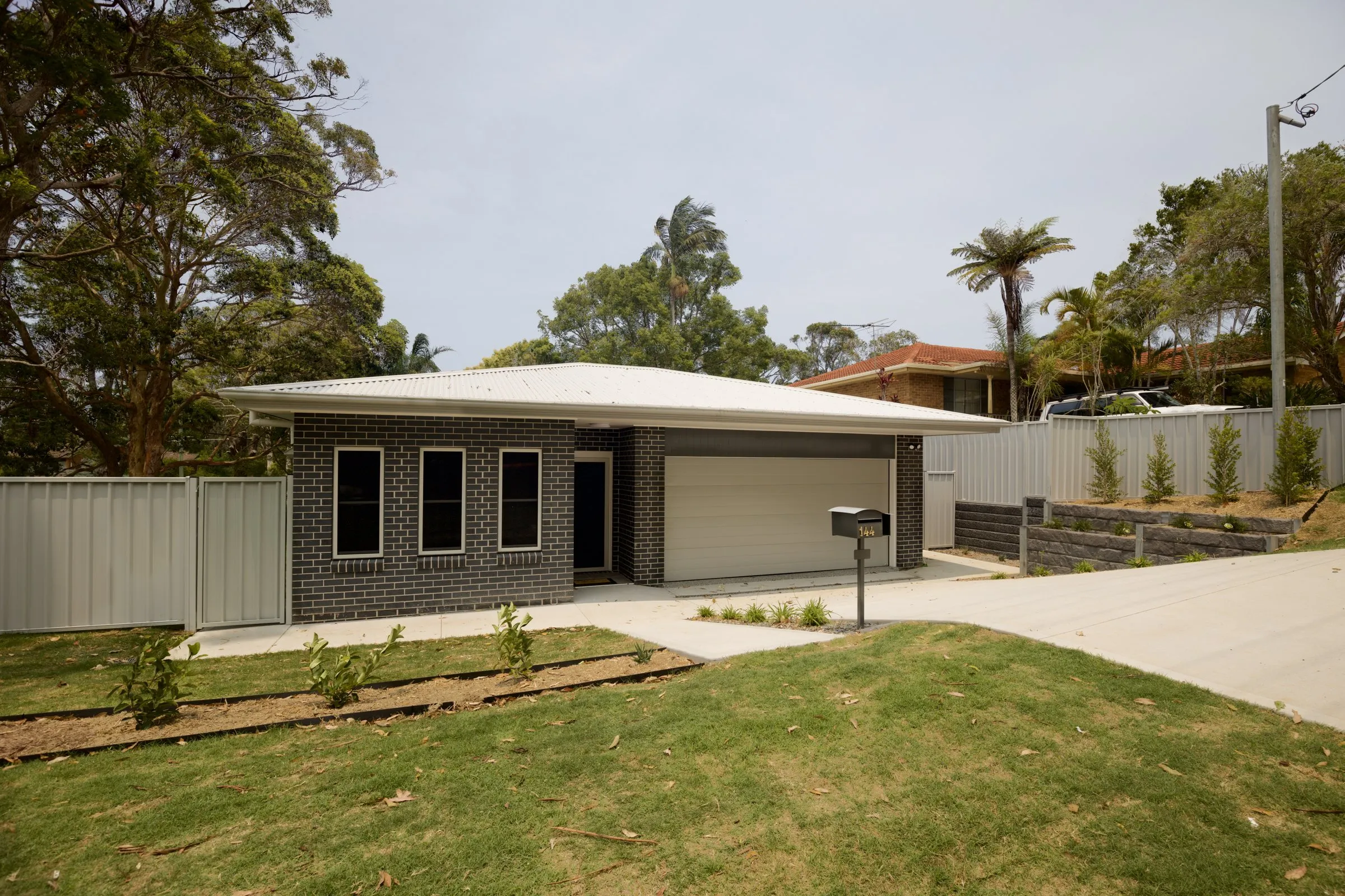 Front of a new brick home with a fresh lawn, real estate photography by Kris Cook